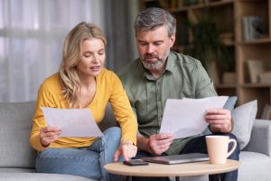 Family at home reviewing Finances as they are struggling to get by each month
